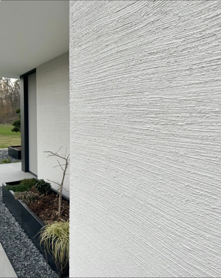 Weiße moderne Hausfassade mit gleichmäßig ausgeführter horizontaler Putzstruktur